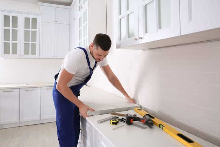 A contractor finishing kitchen remodel countertops in Syracuse, NY.